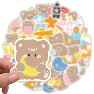 Close-up of a waterproof brown bear sticker holding a yellow moon for DIY decoration