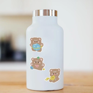 Detailed view of DIY cartoon bear stickers on a white matte stainless steel water bottle