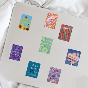 Close-up of cute cartoon stickers on a laptop featuring retro quotes and floral designs