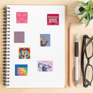 Close-up of waterproof cartoon stickers with retro graphics on a notebook and wooden desk