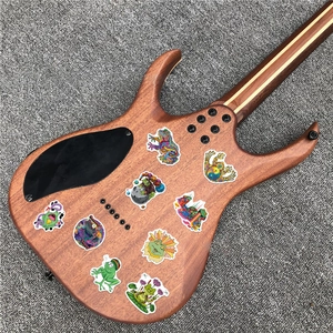Detailed view of colorful psychedelic frog stickers on a brown wood guitar body