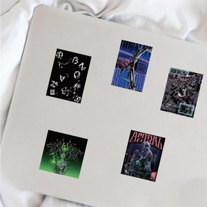 Close-up of Y2K style stickers with metallic liquid designs on a laptop lid