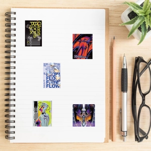 Flat lay of futuristic Harajuku style stickers on a white notebook and wood desk