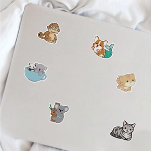 Detailed close-up of colorful waterproof cartoon animal stickers on a silver laptop lid