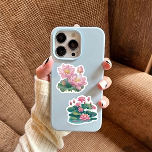 Close-up of pink lotus stickers on a light blue phone case with a soft textured finish