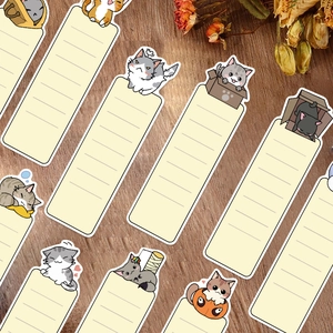 Set of 30 cute cartoon cat bookmarks and paper memos on a rustic wooden desk
