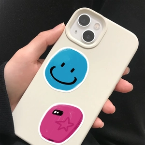 Close-up of cream silicone phone case featuring blue smiley face and pink star graffiti