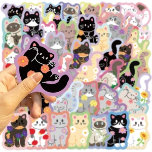 Close-up of cute cartoon cat stickers with floral accents for scrapbooking and laptops