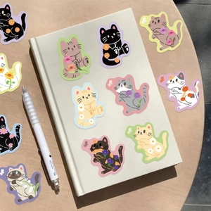 Close-up of cute cartoon cat and flower stickers on a notebook with warm office vibes