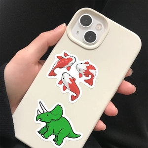 Detail of waterproof cartoon koi and dinosaur stickers applied on a beige phone case