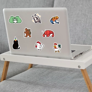 Close-up of cute animal stickers on a silver laptop including bears and frogs