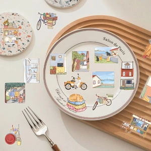Artistic PET stickers featuring cozy home scenes and cats scattered on a white plate