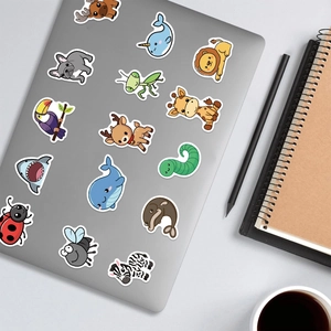 Detail of cute animal cartoon stickers applied on a laptop with minimalist desk accessories
