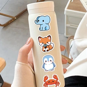 Close-up of cute cartoon animal stickers applied on a cream-colored travel thermos cup