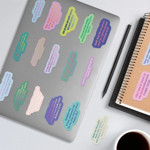Macro shot of colorful scripture stickers in Morandi tones on a silver laptop surface
