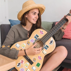 Detalle de pegatinas decorativas de lectura en una guitarra con colores estéticos