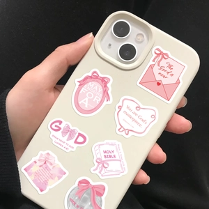 Pink coquette bow and scripture stickers decorating a cream phone case with soft aesthetics