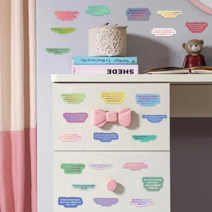 Close-up of colorful Bible verse stickers applied to a white drawer in a home setting