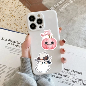 Detail of cute Halloween ghost and pumpkin stickers applied on a white phone case cover