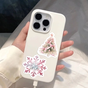 Gros plan d'autocollants sapin de Noël et flocon de neige sur une coque blanche