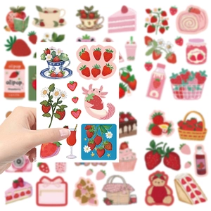 Close-up of cute strawberry stickers for DIY journals featuring cartoon fruits and animals