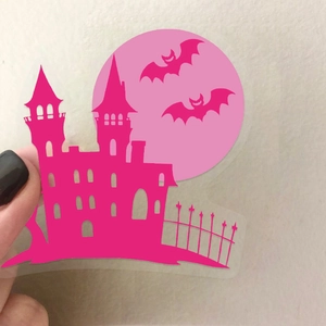 Close-up of pink transparent Halloween sticker showing gothic castle and bats