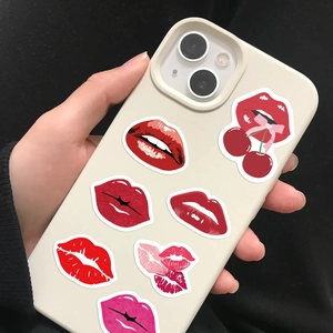 Detail view of cream phone case featuring trendy red lips and cherry bow pattern stickers