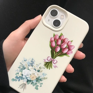 Detail of cream phone case featuring pink tulips and yellow roses on a black background