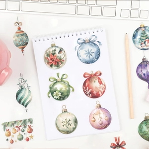 Watercolour Christmas bell stickers displayed on a notebook with festive holiday ornaments