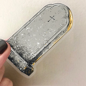 Detailed view of vintage tombstone sticker with black cross and gothic texture