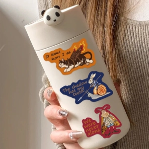 Detail of medieval eerie doodle stickers on a cream ceramic thermos with panda lid decoration