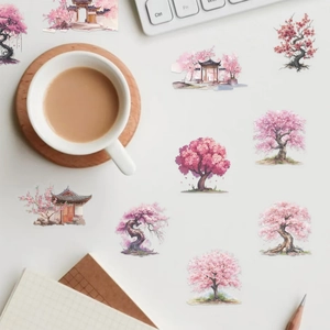 Macro shot of sakura watercolor stickers on a notebook with laptop and coffee cup