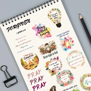 Détail d'autocollants de versets bibliques sur un carnet blanc avec des motifs à l'aquarelle douce