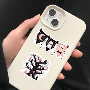 Pink and black Halloween stickers with ghost and moon designs on a cream phone case