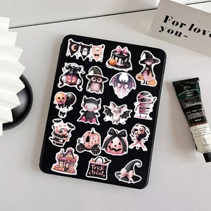 Pink and black Halloween stickers on a tablet featuring pumpkins, ghosts and bats