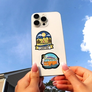 Outdoor camping stickers with tent and vintage van patterns on a white mobile phone case