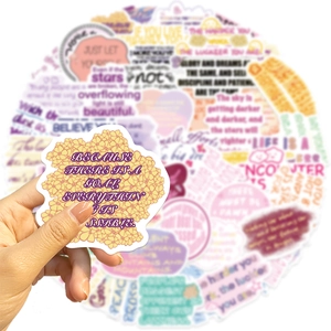 Close-up of matte motivational quote stickers with yellow floral patterns and purple font