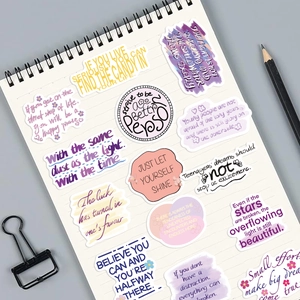 Close-up of decorative waterproof motivational English stickers on a spiral notebook