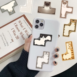 Waterproof Tetris cat stickers on a white iPhone next to a book on a clean desk