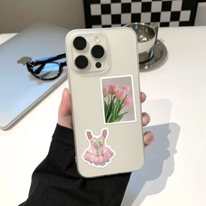 Close-up of semi-transparent phone case with pink tulip and ballet dress stickers