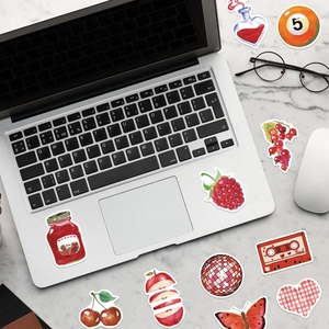 Autocollants Cherry Downtown rouges sur ordinateur portable argenté sur table en marbre