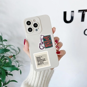 Close-up of horror movie stickers on a phone case featuring retro phone and quote designs