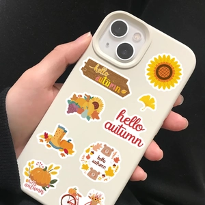 Close-up of autumn-themed stickers on a phone case featuring pumpkin and sunflower motifs
