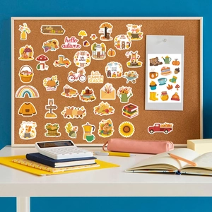 Detail of autumn stickers featuring fox and owl on corkboard with cozy desk accessories