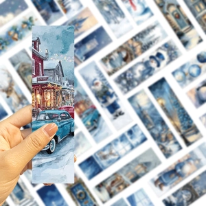 Gros plan détaillé d'un marque-page de Noël bleu montrant une scène de ville hivernale enneigée