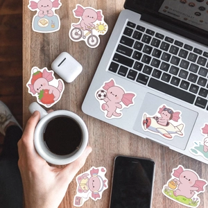 Gros plan d'autocollants de dessin animé axolotl rose décorant un ordinateur portable