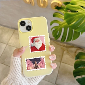 Detail showing pink Christmas stamp graphics on a creamy yellow iPhone phone case