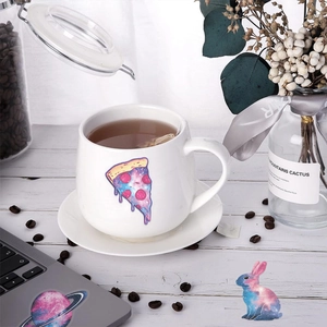 Detailansicht von Sternenhimmel-Stickern auf Keramiktasse und Laptop-Oberfläche