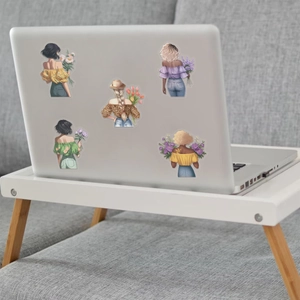 Close-up of colorful floral girl stickers applied on a silver laptop back cover