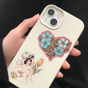 Detail of glitter laser flower fairy sticker on a white phone case held by hand